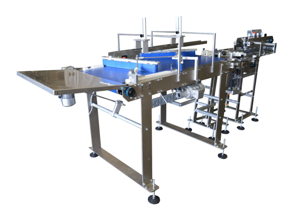 Sistema di trasporto e allineamento automatico per muffin e prodotti da forno pronti per il confezionamento.